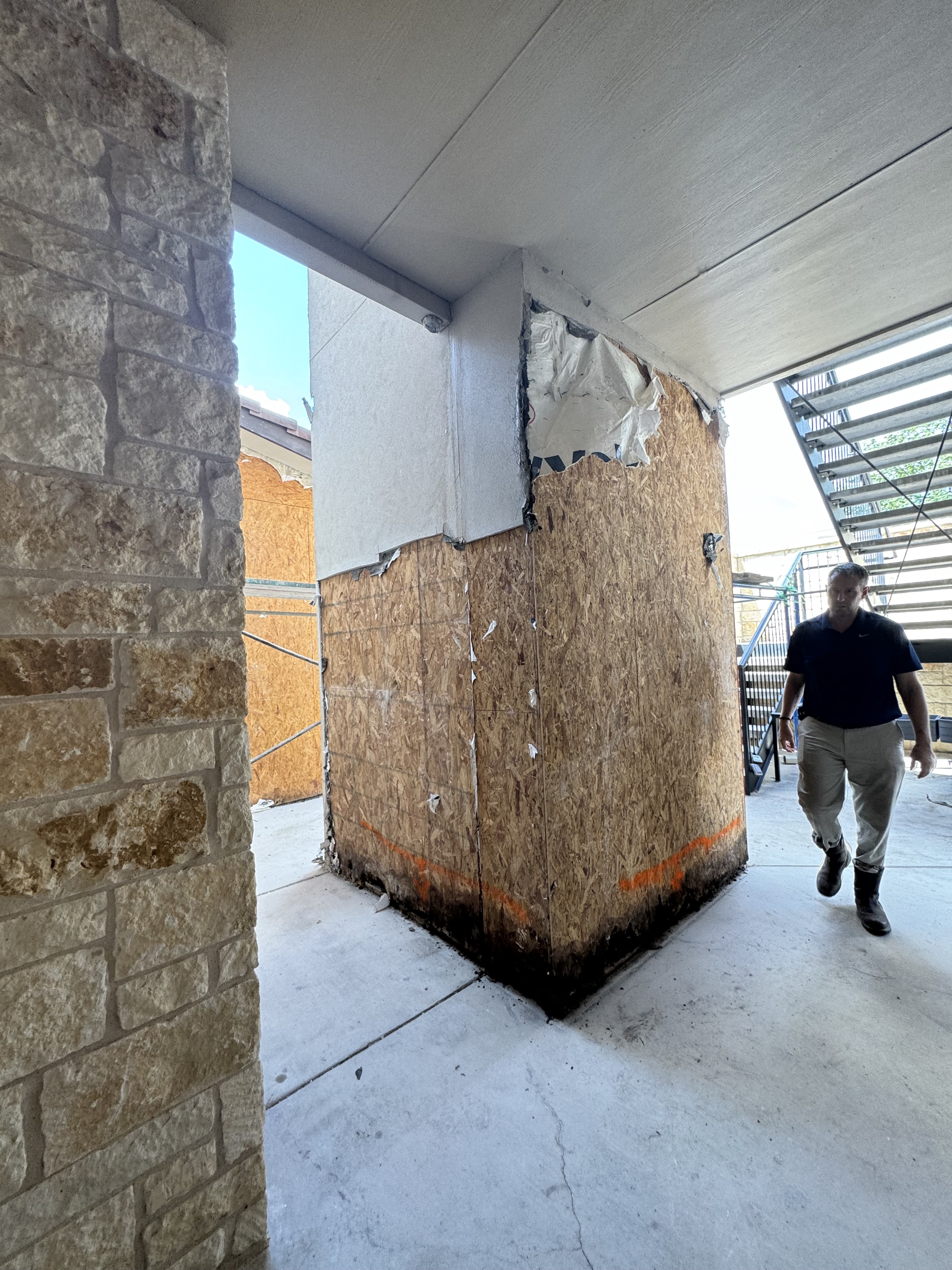 Water-damaged wood sheathing exposed behind an exterior wall