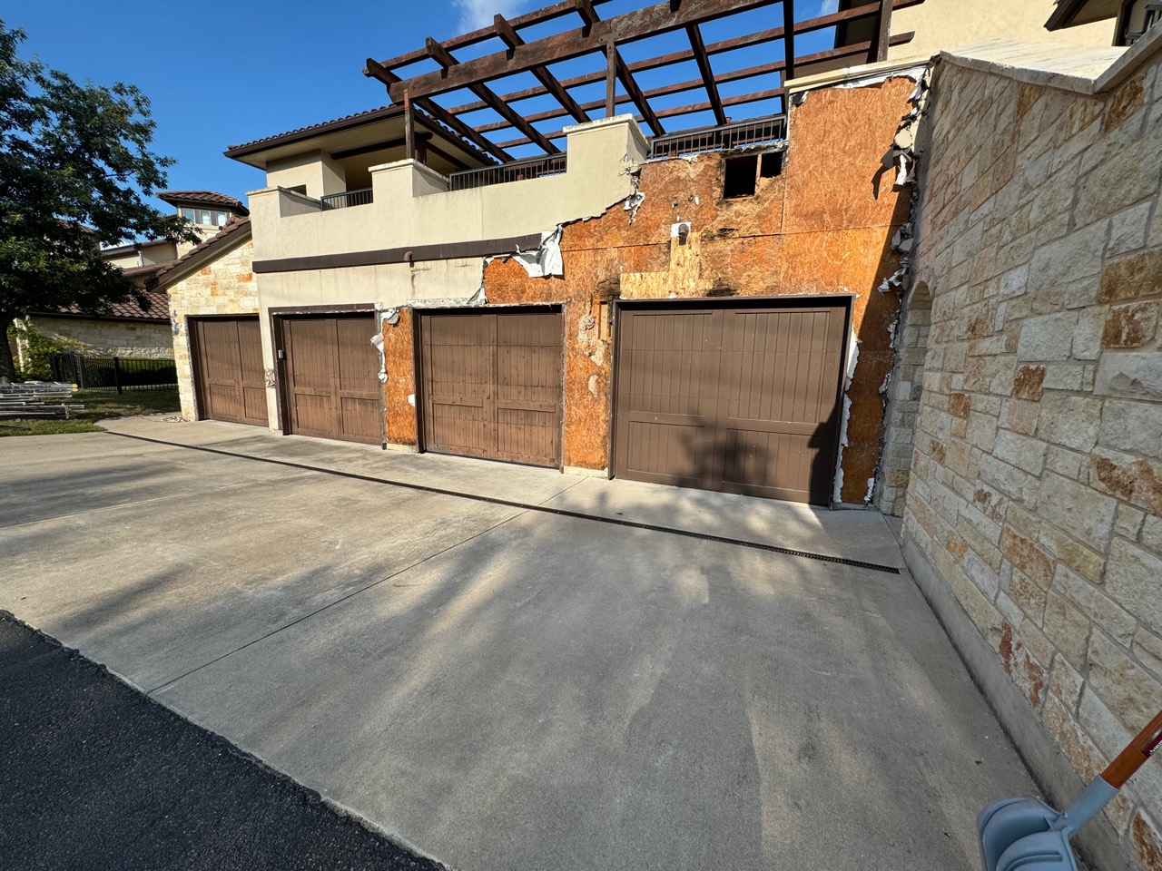 Exterior wall opened around garage doors during waterproofing repair